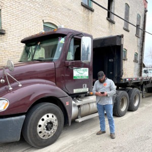 Truck driver using the Turf Logistics app for Green Acres sod loading and delivery.